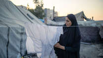 Girl hangs up washing on washing line.