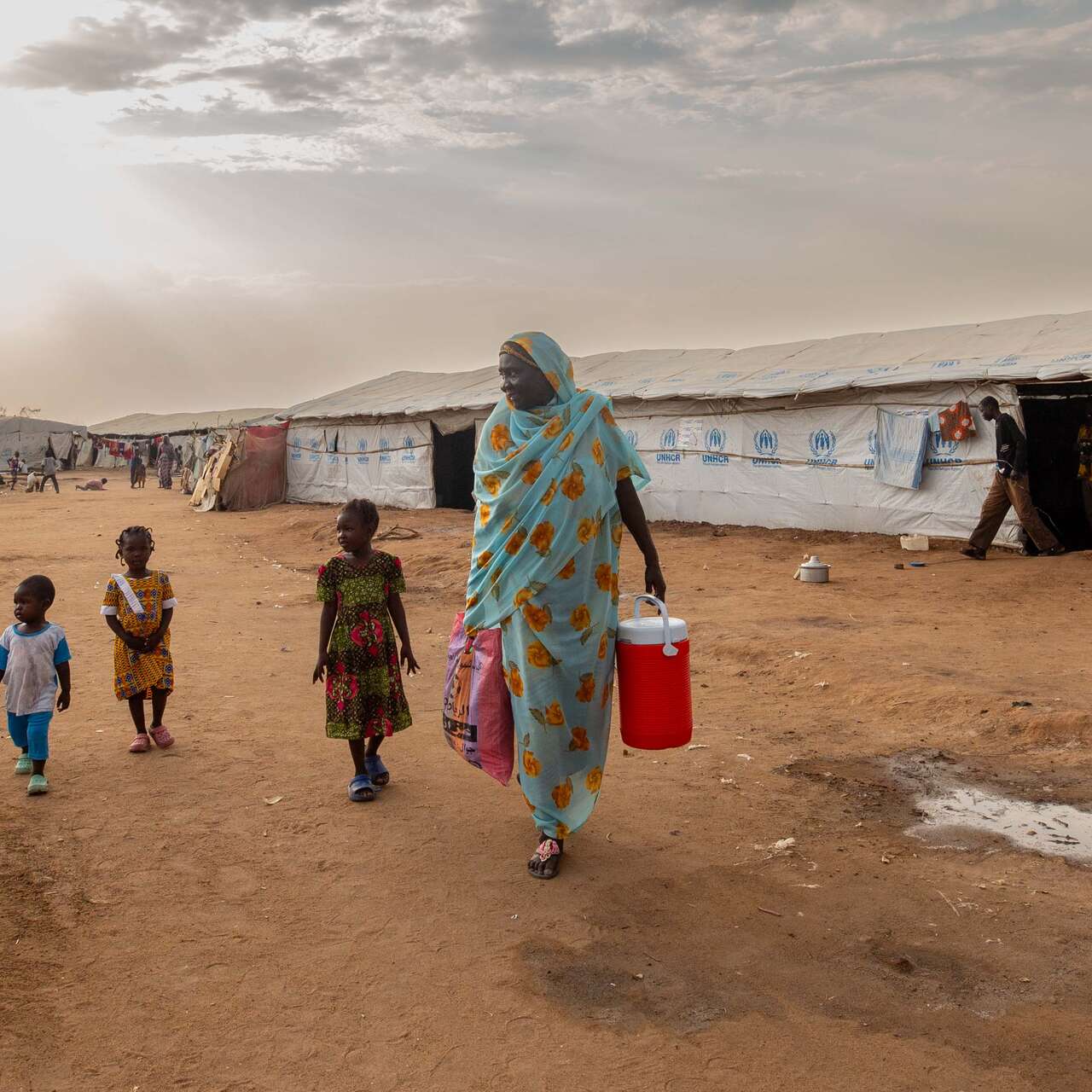 Fairuz stands outside the camp with her grandchildren.